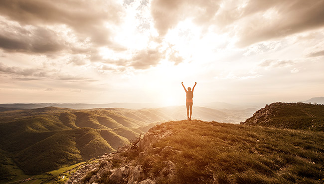 Back of women with her hands up outdoors during a hike