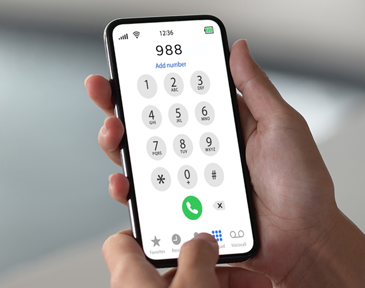 A closeup of a mobile device, someone is dialing 988